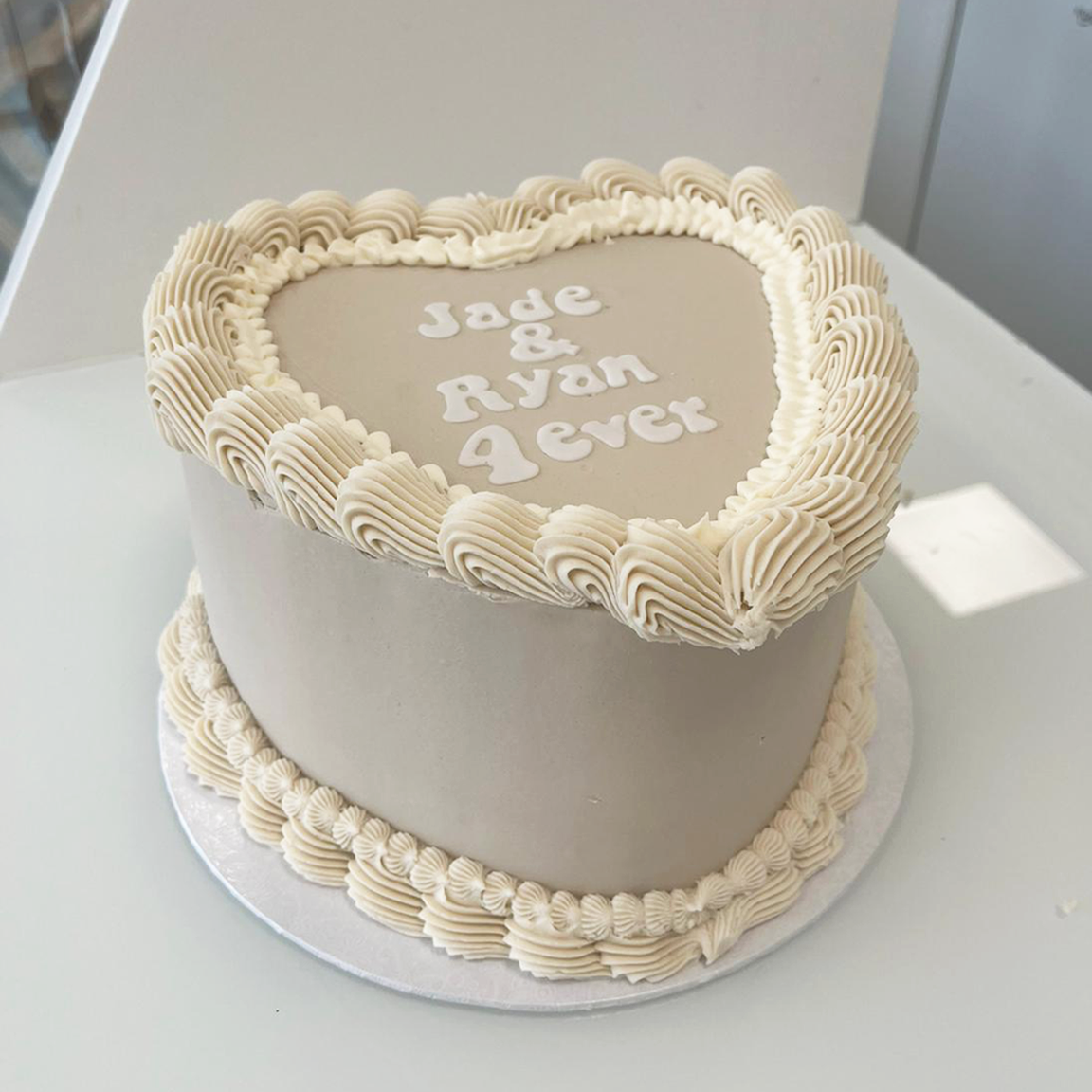 Cream and nude heart vintage cake, with the message 'Jade & Ryan 4ever' in white bubble writing. 